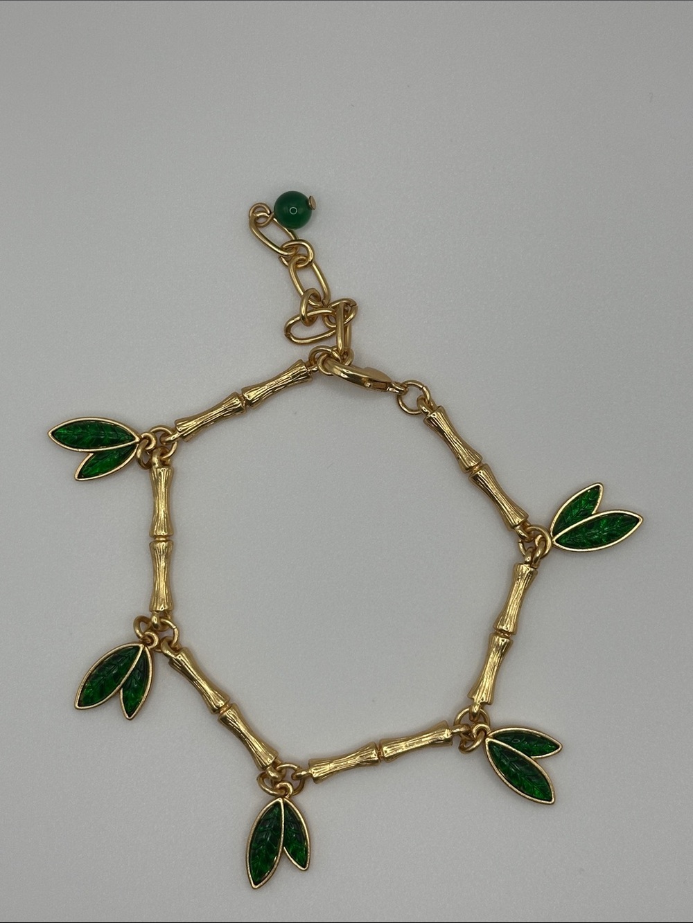 Gold Bamboo Charm Bracelet with Green Leaf Accents
